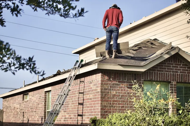 Professional roofer working on a residential roof in Village